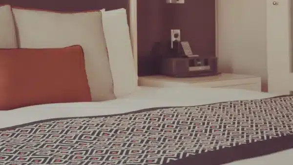 ein gemütliches Bett mit Tagesdecke