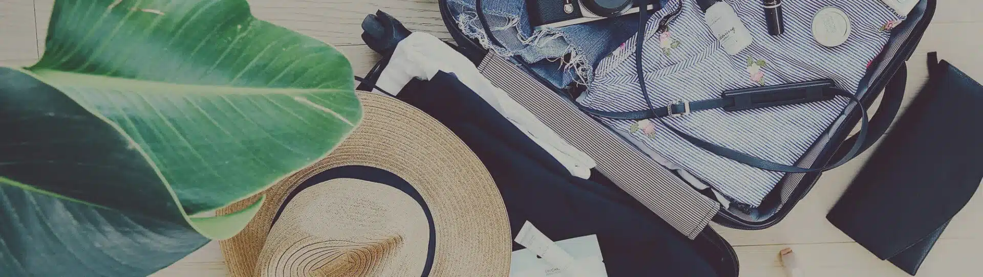 gepackter Koffer mit Hut, Kleidung bereit für den Versand