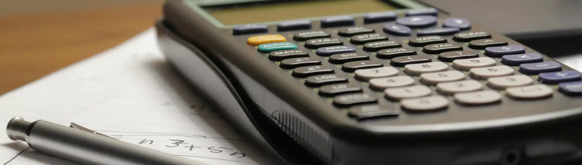 Kostenrechner und Kugelschreiber auf einem Schreibtisch