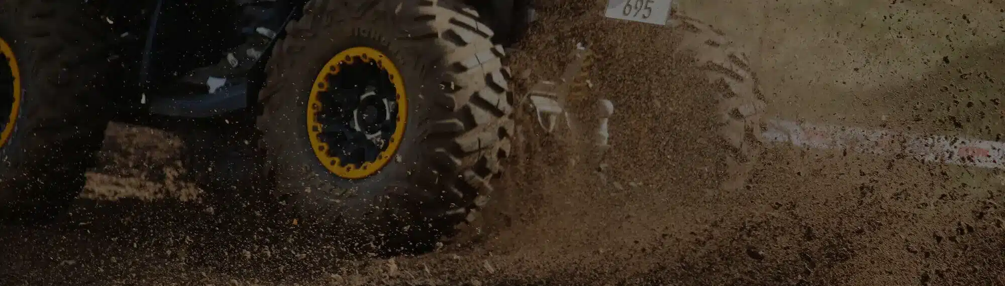 Quad fährt schnell auf einer matschigen Hügelpiste